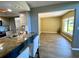 Open concept kitchen with granite counters, eat-in bar, and wood plank flooring at 3276 Hilary Cir, Palm Harbor, FL 34684