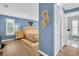 Light-filled bedroom features hardwood floors, a large window with shutter and access to the en-suite bathroom at 3276 Hilary Cir, Palm Harbor, FL 34684