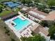 Aerial view of community pool with lounge chairs, umbrellas, and palm trees at 3276 Hilary Cir, Palm Harbor, FL 34684