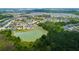 Aerial view of a neighborhood featuring a pond, lush greenery, and well-maintained homes at 33176 Whisper Pointe Dr, Wesley Chapel, FL 33545
