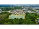 Aerial view of a community surrounded by lush greenery and a serene pond at 33176 Whisper Pointe Dr, Wesley Chapel, FL 33545