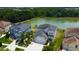 Expansive aerial view showcasing the home's proximity to a serene pond and lush green surroundings at 33176 Whisper Pointe Dr, Wesley Chapel, FL 33545