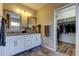 Bathroom features double sinks, hard surface counters, and a view into an organized walk-in closet at 33176 Whisper Pointe Dr, Wesley Chapel, FL 33545