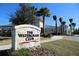 Attractive neighborhood sign for 'The Watergrass Club' surrounded by palm trees and lush landscaping at 33176 Whisper Pointe Dr, Wesley Chapel, FL 33545