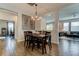 Dining room boasts modern lighting fixture, wood-look tile flooring and adjoined living spaces at 33176 Whisper Pointe Dr, Wesley Chapel, FL 33545