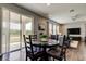 Well-lit dining area with access to a covered patio overlooking a serene lake, hardwood flooring throughout at 33176 Whisper Pointe Dr, Wesley Chapel, FL 33545