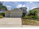 Charming two-story home with a three-car garage, well-maintained landscaping, and a covered entryway at 33176 Whisper Pointe Dr, Wesley Chapel, FL 33545