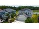 Stunning home featuring a three-car garage, mature landscaping, and a view of the adjacent pond at 33176 Whisper Pointe Dr, Wesley Chapel, FL 33545
