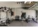 Spacious home gym featuring a variety of weight training equipment, black rubber floor, and ample lighting at 33176 Whisper Pointe Dr, Wesley Chapel, FL 33545