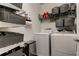 Laundry room featuring modern washer and dryer, built-in shelves and storage baskets at 33176 Whisper Pointe Dr, Wesley Chapel, FL 33545