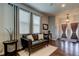 Cozy living room featuring a brown leather loveseat, wood-look tile flooring, and lots of natural light at 33176 Whisper Pointe Dr, Wesley Chapel, FL 33545