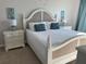 Bright bedroom features a decorative headboard and seahorse wall art at 3400 Gulf Blvd # 102, Belleair Beach, FL 33786