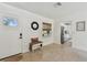 Bright entryway featuring a white door, a small bench, and views into the kitchen, dining, and living area at 36846 Jefferson Ave, Dade City, FL 33523