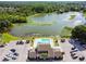 This aerial view shows a club house and private pool close to a lake surrounded by lush greenery at 3824 Cortez Dr # B, Tampa, FL 33614
