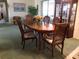 Traditional dining room with wood table, chairs, china cabinet and slider in background at 3850 Sablewood Dr, Holiday, FL 34691