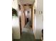 Hallway displaying three doors and green carpet flooring at 3850 Sablewood Dr, Holiday, FL 34691