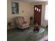 Cozy living room with a plush armchair, glass coffee table, and warm, inviting decor at 3850 Sablewood Dr, Holiday, FL 34691