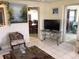 Bright living room with tile flooring, decorative chair, and views into the dining area at 3850 Sablewood Dr, Holiday, FL 34691