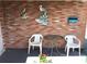Cozy covered patio with brick wall, adorned with wall art and equipped with table and chairs for outdoor relaxation at 3850 Sablewood Dr, Holiday, FL 34691