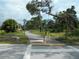 Scenic view of the Anclote Trail showing paved path, lush greenery and a designated crosswalk at 3850 Sablewood Dr, Holiday, FL 34691