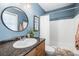 Blue bathroom with vanity, round mirror, and a shower-tub combo at 5003 Starfish Dr Se # B, St Petersburg, FL 33705