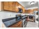 Well-lit kitchen features wood cabinetry, granite counters, and stainless steel appliances at 5003 Starfish Dr Se # B, St Petersburg, FL 33705