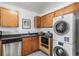 Cozy kitchen featuring stainless appliances, granite counters, and convenient stacked washer and dryer at 5003 Starfish Dr Se # B, St Petersburg, FL 33705