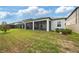 Spacious backyard featuring a covered screened patio and well-maintained lawn, ideal for outdoor living at 5059 Bromeliad Ave, Wimauma, FL 33598