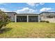 Spacious backyard features a screened lanai, lush green grass, and a private, fenced yard at 5059 Bromeliad Ave, Wimauma, FL 33598
