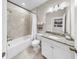 Bright bathroom featuring tiled shower and bath, vanity with granite counters and decorative mirror at 5059 Bromeliad Ave, Wimauma, FL 33598