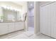 Well-lit bathroom featuring double vanity with stone counters, tiled floors, and walk-in shower at 5059 Bromeliad Ave, Wimauma, FL 33598