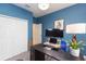 Cozy bedroom featuring blue walls, a dark desk, and a modern chandelier at 5059 Bromeliad Ave, Wimauma, FL 33598