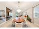 Stylish dining area with modern chandelier, wood accent wall, and seating for six at 5059 Bromeliad Ave, Wimauma, FL 33598