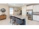 Modern kitchen featuring granite countertops, stainless steel appliances, and a spacious island with seating at 5059 Bromeliad Ave, Wimauma, FL 33598