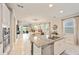 Bright open kitchen with granite countertops, stainless steel appliances, and neutral tile floors at 5059 Bromeliad Ave, Wimauma, FL 33598