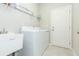 Well-equipped laundry room features a large sink, updated washer and dryer, and ample storage space at 5059 Bromeliad Ave, Wimauma, FL 33598