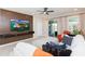 Modern living room with decorative wood wall and sliding glass doors that provide views of backyard at 5059 Bromeliad Ave, Wimauma, FL 33598