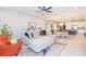 Open-concept living room features a modern ceiling fan, plush sectional sofa, and seamless flow to the kitchen at 5059 Bromeliad Ave, Wimauma, FL 33598