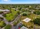 Aerial view showcasing lush greenery, a lake, tennis court, and neighborhood amenities at 5102 Coquina Key Se Dr # D, St Petersburg, FL 33705