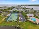 Community aerial view featuring a pool, clubhouse, tennis courts and landscaping near the water at 5102 Coquina Key Se Dr # D, St Petersburg, FL 33705