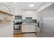 Modern kitchen showcasing white cabinetry, stainless steel appliances, and a decorative shelf at 5102 Coquina Key Se Dr # D, St Petersburg, FL 33705