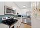 Bright kitchen featuring white cabinets, stainless steel appliances, and an electric cooktop at 5102 Coquina Key Se Dr # D, St Petersburg, FL 33705