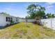 Well-maintained backyard features lush green grass, landscaping and a white fence at 5117 Fitchburg Dr, Holiday, FL 34690