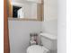 Bathroom featuring a toilet, mirror, and white wainscoting at 5117 Fitchburg Dr, Holiday, FL 34690