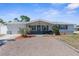 A charming home with a well-kept front yard, complemented by a gray roof and a gravel driveway at 5117 Fitchburg Dr, Holiday, FL 34690