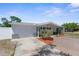 Charming single-story home showcasing a well-manicured front yard and a one car garage on a sunny day at 5117 Fitchburg Dr, Holiday, FL 34690