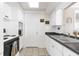 Bright kitchen with white cabinets, gray counters, tile backsplash, and linoleum flooring at 5117 Fitchburg Dr, Holiday, FL 34690