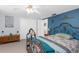 Main bedroom with blue accent wall, iron bed frame and carpet at 5117 Fitchburg Dr, Holiday, FL 34690
