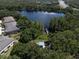 Aerial view of a lake surrounded by lush trees, a small dock, community residences and natural landscapes at 6225 Scarlet Darter Way, Tampa, FL 33625