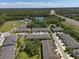 Aerial view of a neighborhood featuring townhouses, a lake, highway access and many mature trees at 6225 Scarlet Darter Way, Tampa, FL 33625